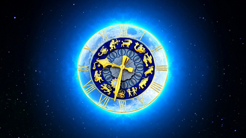 Das Bild zeigt ein stilisiertes Zifferblatt mit astrologischen Symbolen und einem leuchtenden, blauen Hintergrund, der an den Nachthimmel erinnert.