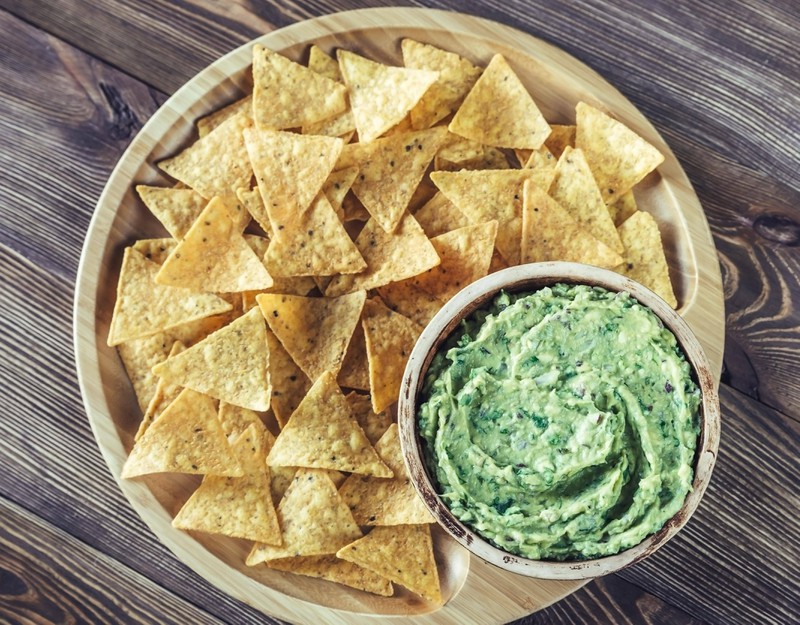 Während Tortilla-Chips nur wenig Kalorien haben, sollte man auf den Dip verzichten.