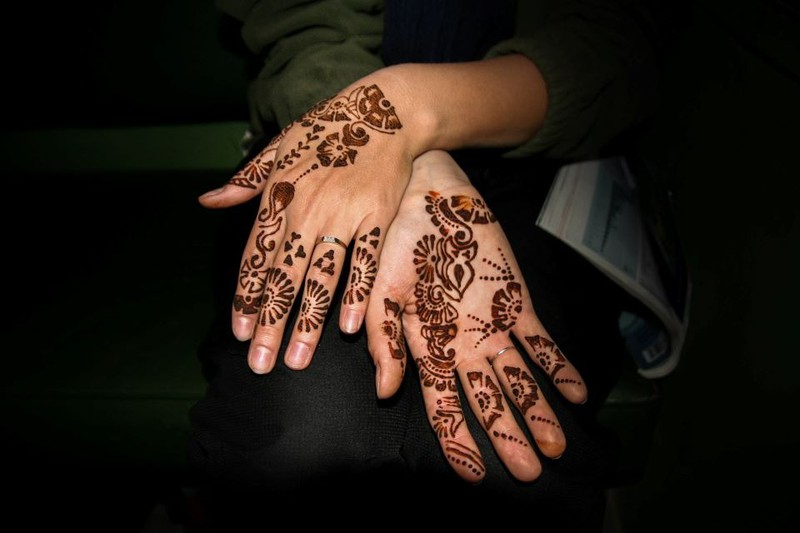 Das Foto zeigt Hände, die mit einem Henna-Tattoo geziert werden