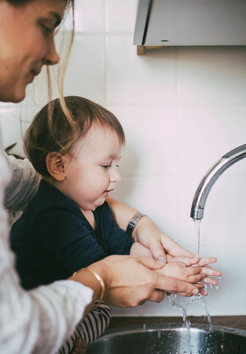 Mutter wäscht Sohn die Hände