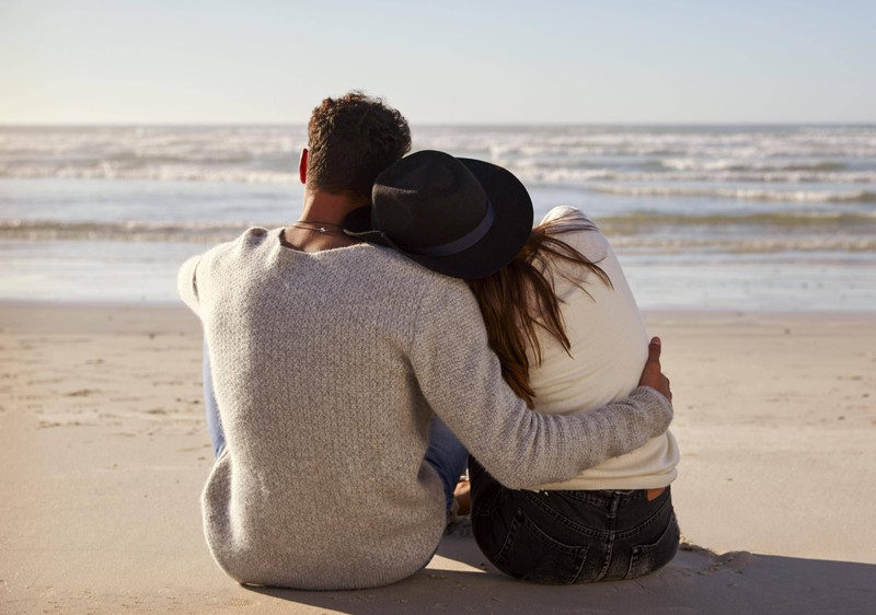 Paar liegt sich am Strand im Arm