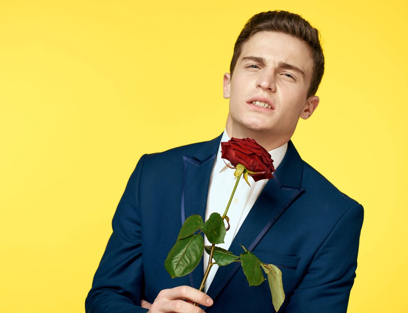 Junger Mann mit einer Rose