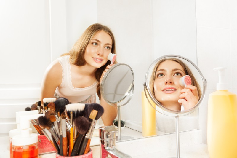 Eine Frau, die sich schminkt und ihr Make-up verteilt hat