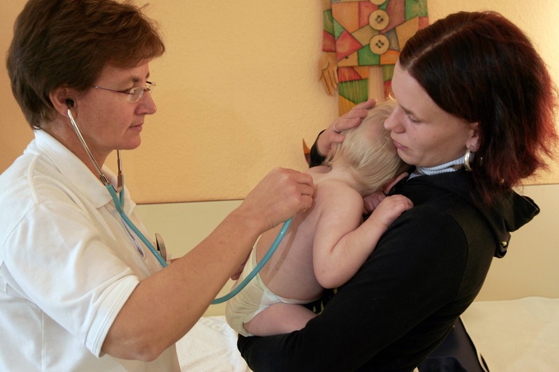 Eine Ärztin kümmert sich um ein Baby.