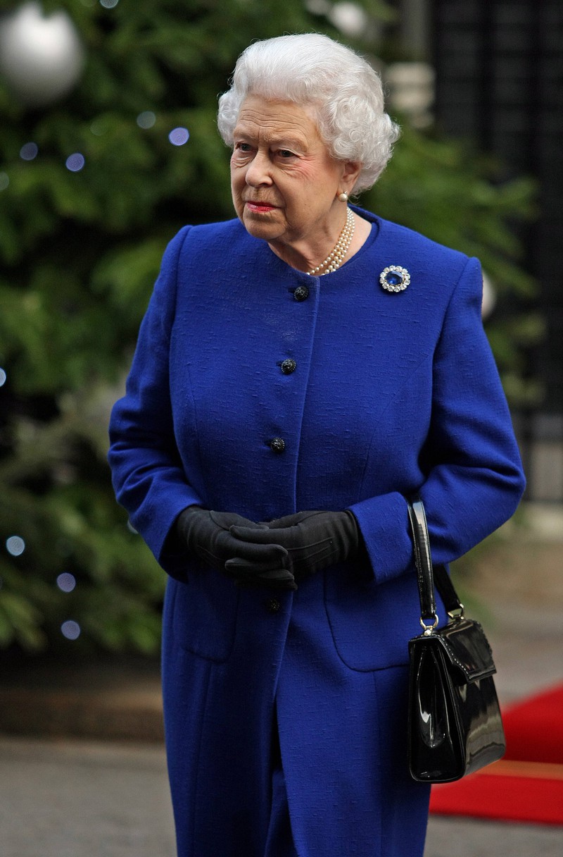 Königin Elizabeth II. kommuniziert mit ihren Angestellten mittels ihrer Handtasche.