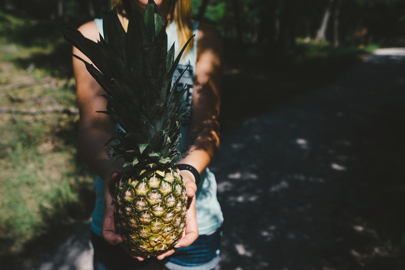 Dieses Bild zeigt eine Frau, die eine Frucht in der Hand hält und für gesunde Ernährung steht.