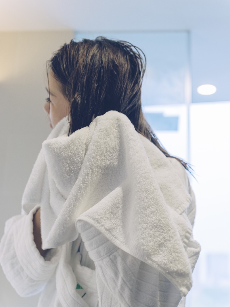 Frau trocknet Haare ab