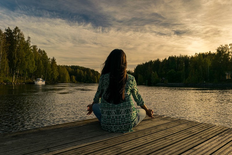 Draußen macht eine Frau Yoga und es geht um Aktivitäten im Sommer