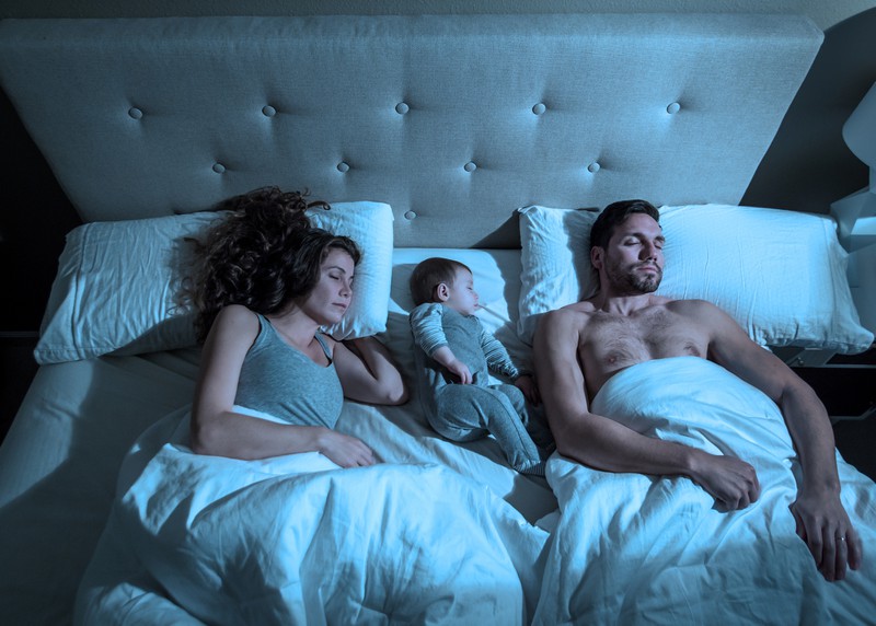 Familie mit Baby im Bett