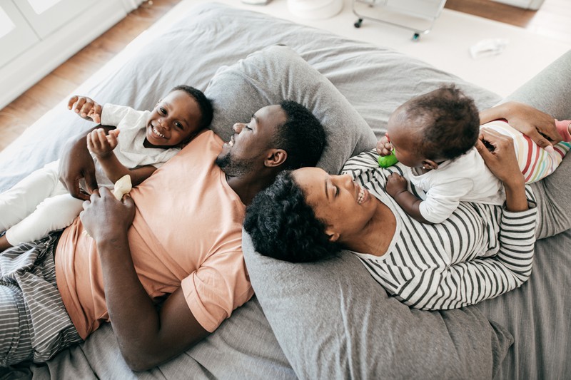Eltern schlafen mit Kindern im Bett