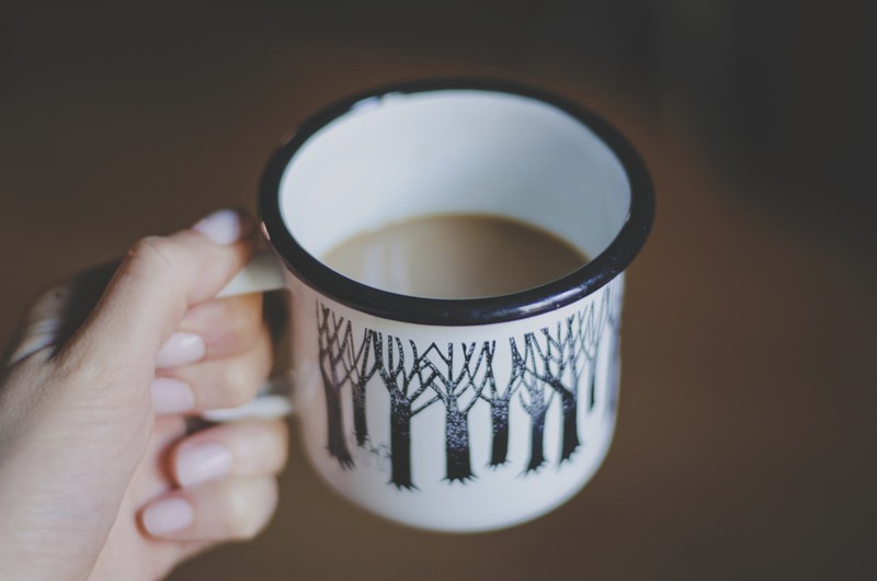 Frau, die eine Kaffeetasse in der Hand hält