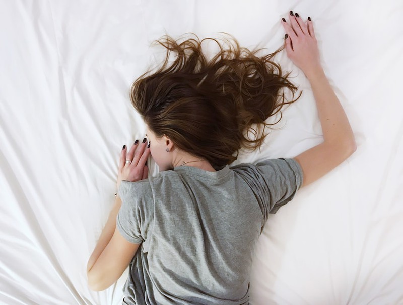 Frau, die mit offenem Haar im Bett liegt