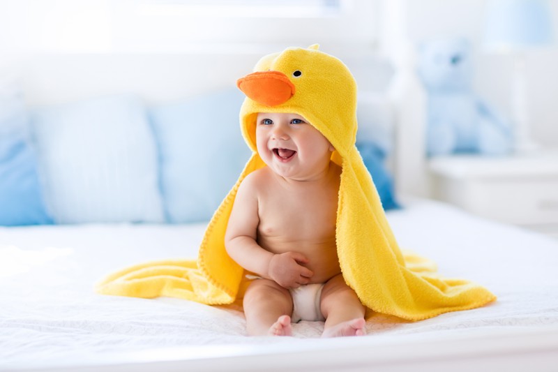 Baby kuschelt mit einer gelben Entendecke
