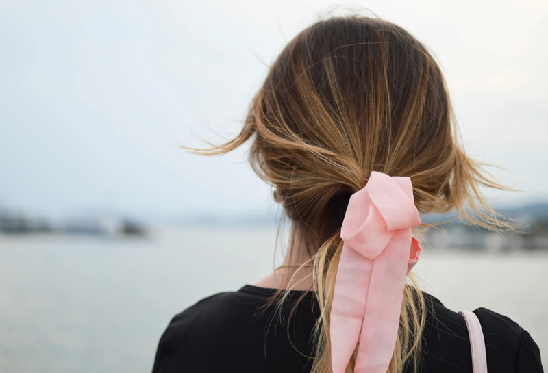 Frau mit einer Haarschleife im Haar, die eine Trendfrisur trägt