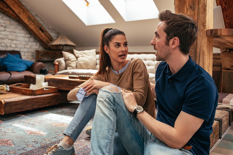 Paar unterhält sich im Wohnzimmer