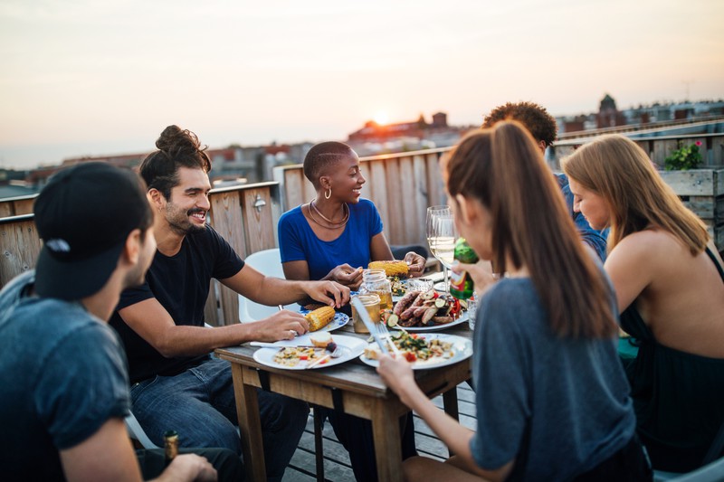 Freundesgruppe beim Abendessen auf dem Dach