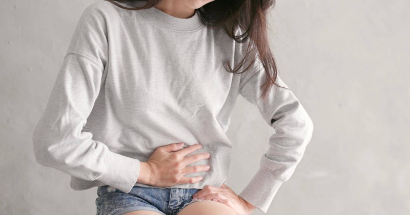 Eine Frau hält sich mit Schmerzen den unteren Bauch