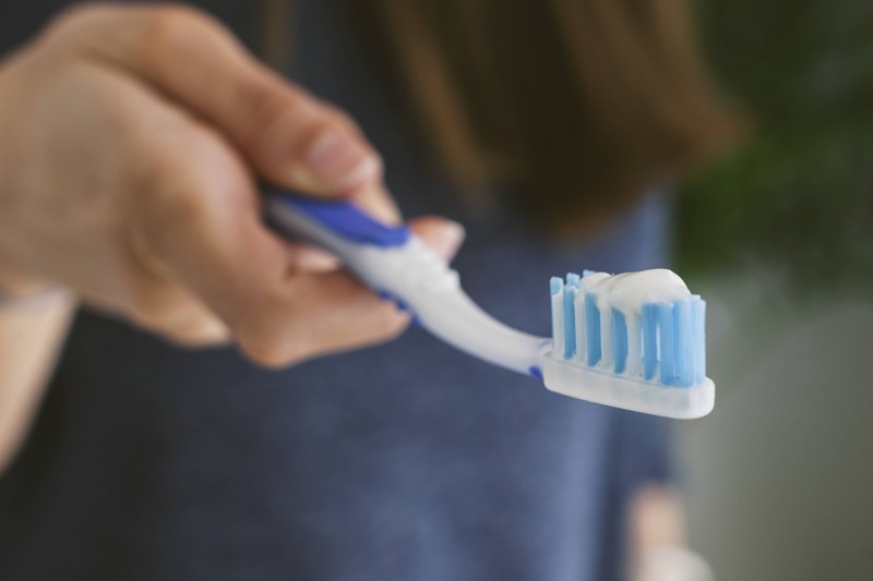 Zahnbürste mit Zahnpasta, wobei letztere gerade für einen kuriosen Intim-Trend genutzt wird