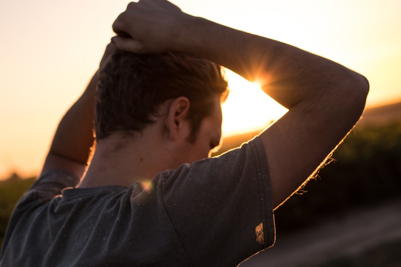 Ein Mann steht im Sonnenuntergang