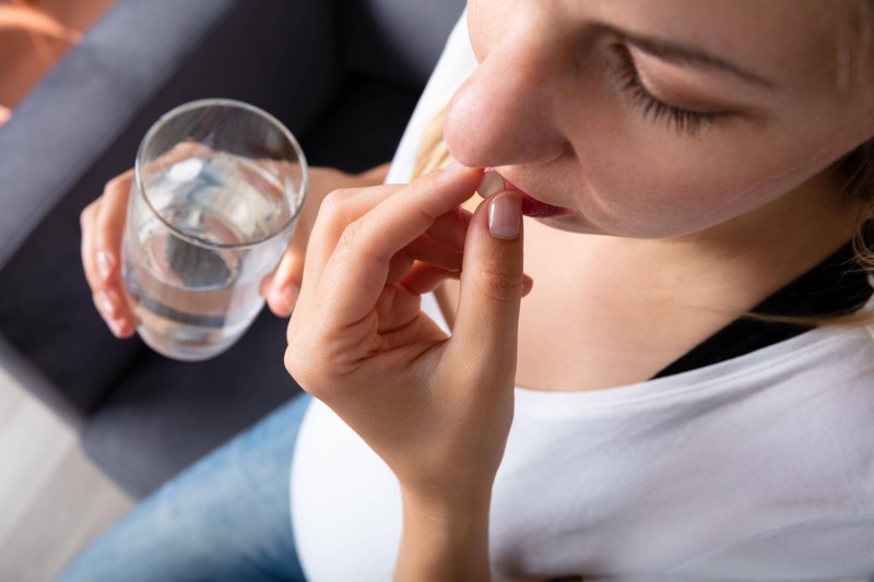 Eine Frau nimmt in der Schwangerschaft eine Paracetamol