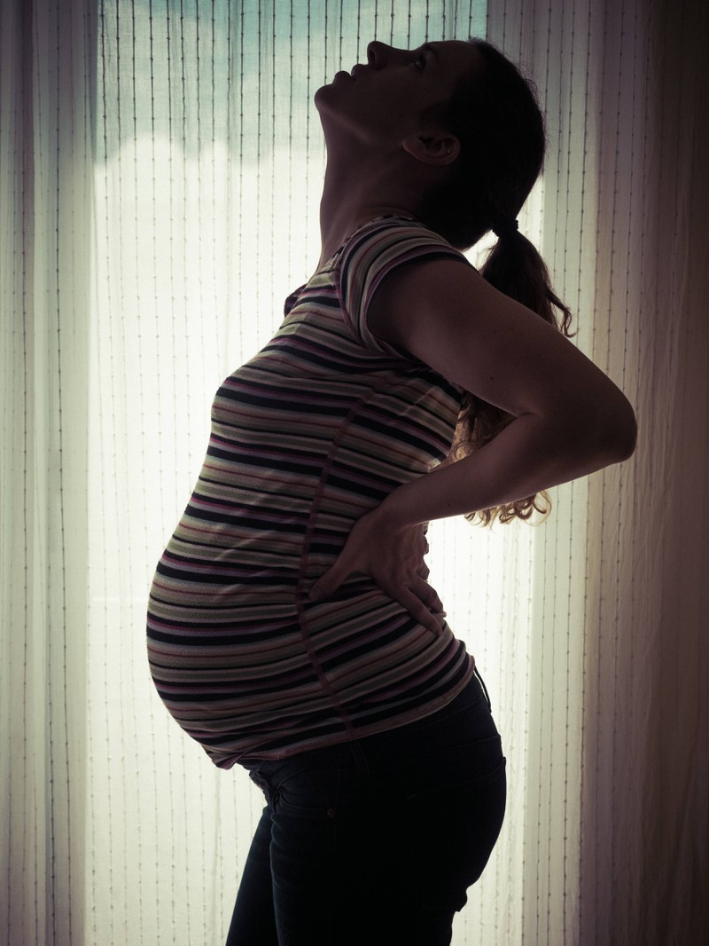 Eine Frau fragt sich, was sie schwanger bei Schnupfen, Husten und Kopfweh  einnehmen kann