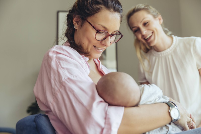 Eine Mutter stillt ihr Kind mit Muttermilch: Aber dem 5. Monat kann sie dies mit Babybrei unterstützen