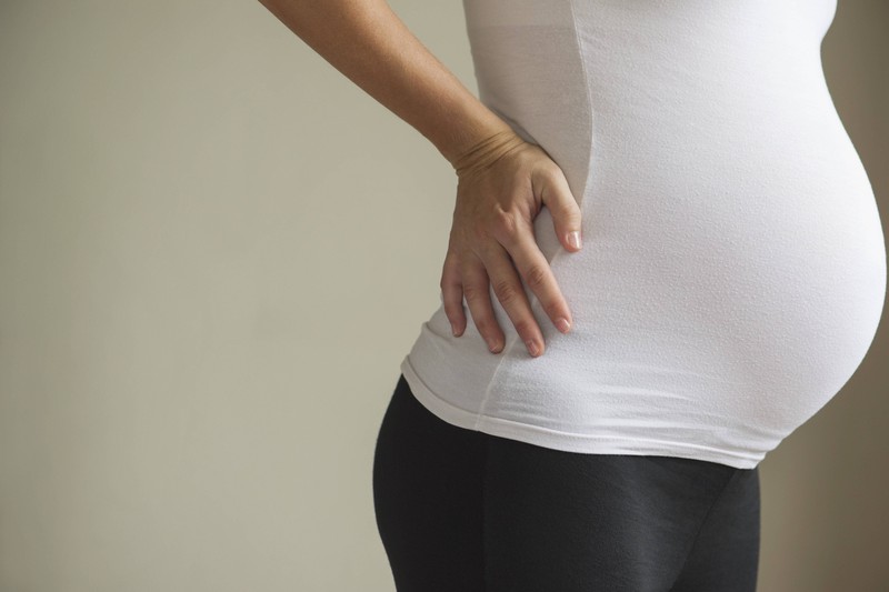 Der Bauch einer Schwangeren, die Wehen erwartet