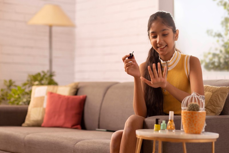 Frauen lackieren sich auch die Fingernägel auf der Couch.