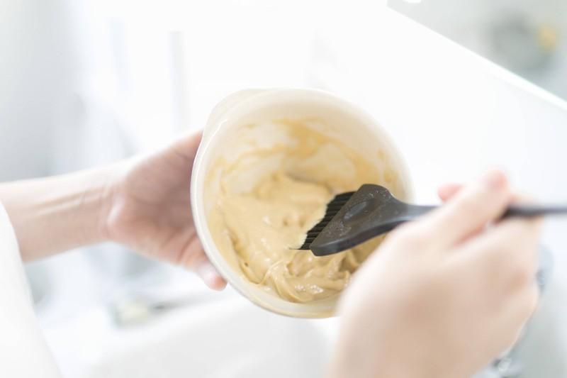 Schale, in der ein Haarfaerbemittel mit einem Pinsel angemischt wird