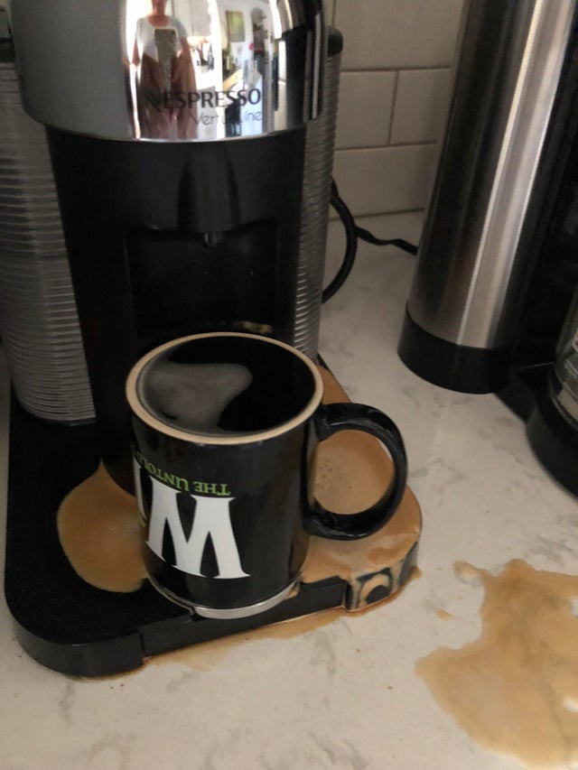 Die Mutter hat die Kaffeetasse falsch herum unter die Kaffeemaschine gestelllt