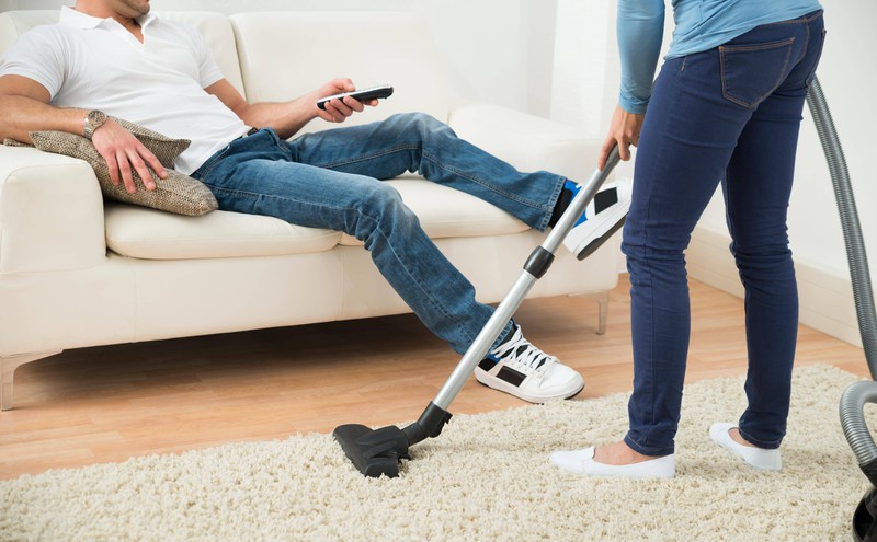 Während sich der Mann ausruht, erledigt die Frau den Haushalt.