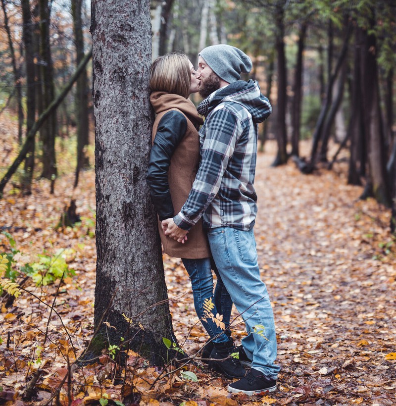 Ein Mann findet eine Frau toll und küsst sie in einem Wald