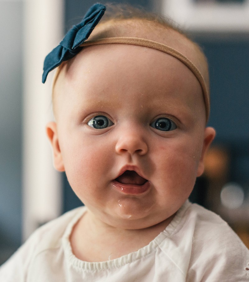 Ein Baby strahlt erstaunt - es hat einen Namen bekommen, der 2021 im Trend liegt