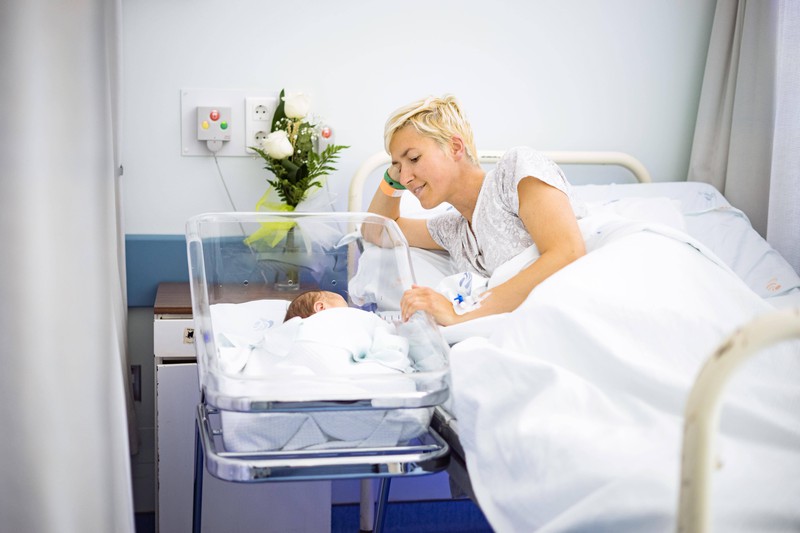Eine Frau wartet auf die Nachsorge der Hebamme nach der Geburt