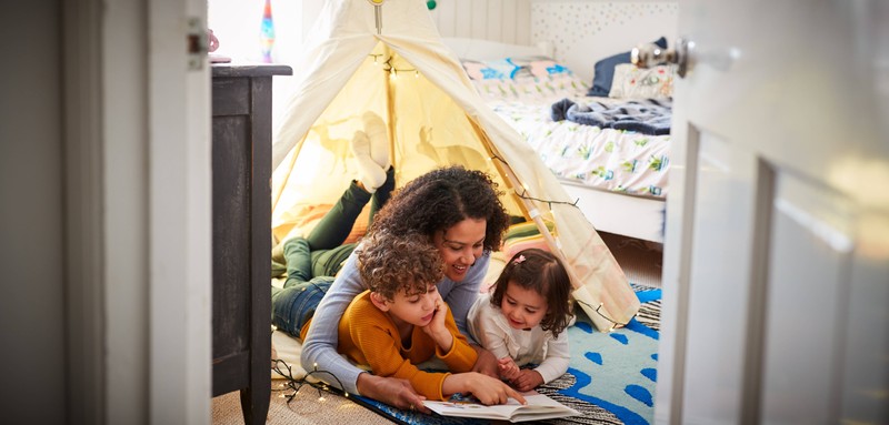Eine Mutter mit ihren Kindern im Kinderzimmer.